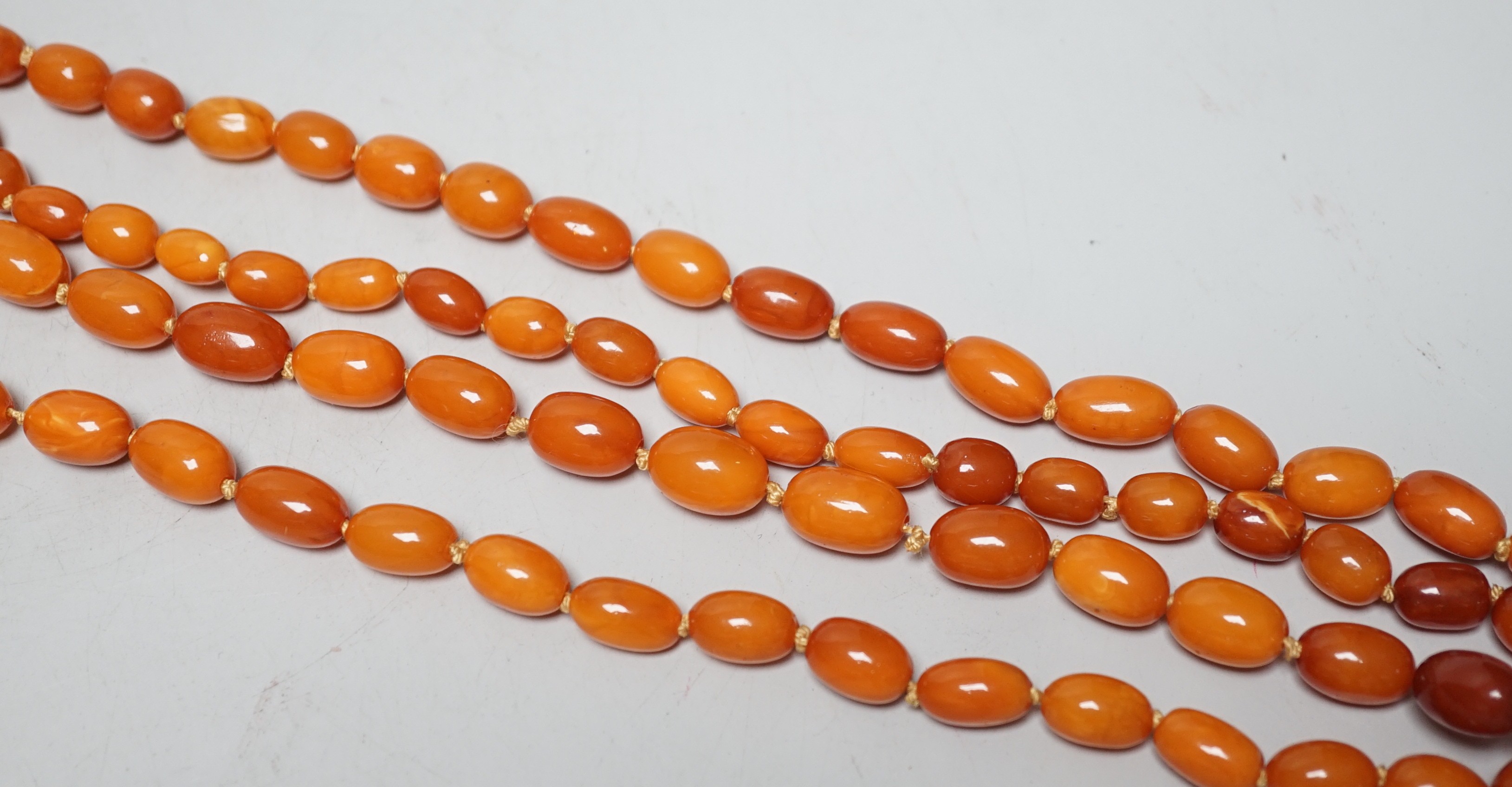 A long single strand graduated oval amber bead necklace(string broken), 142cm, gross weight 51 grams.